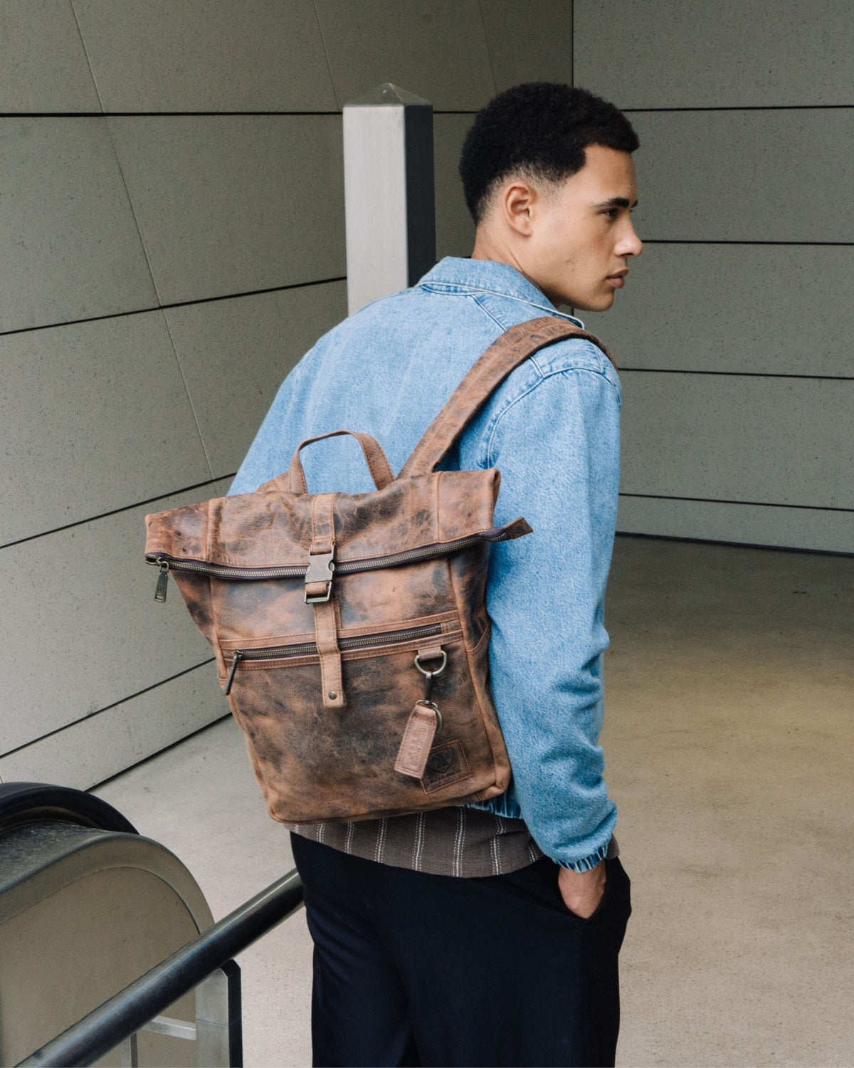 Side view of man wearing earth leather backpack bag