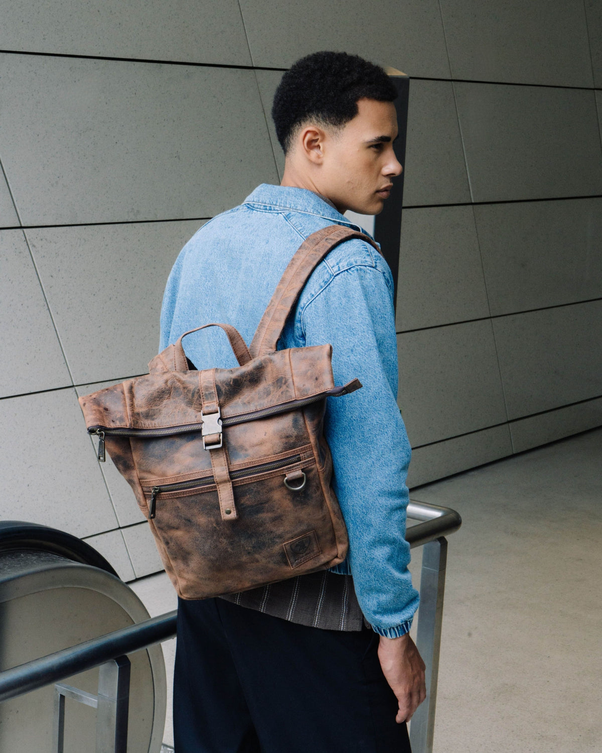 Side view of man wearing earth leather backpack bag