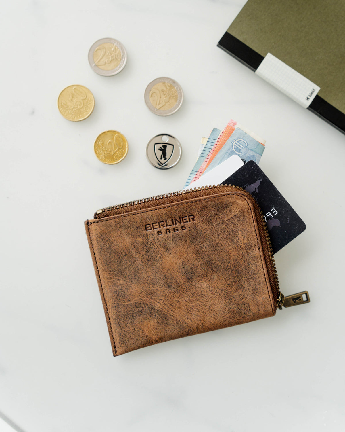 A walnut leather wallet with cash and cards inside