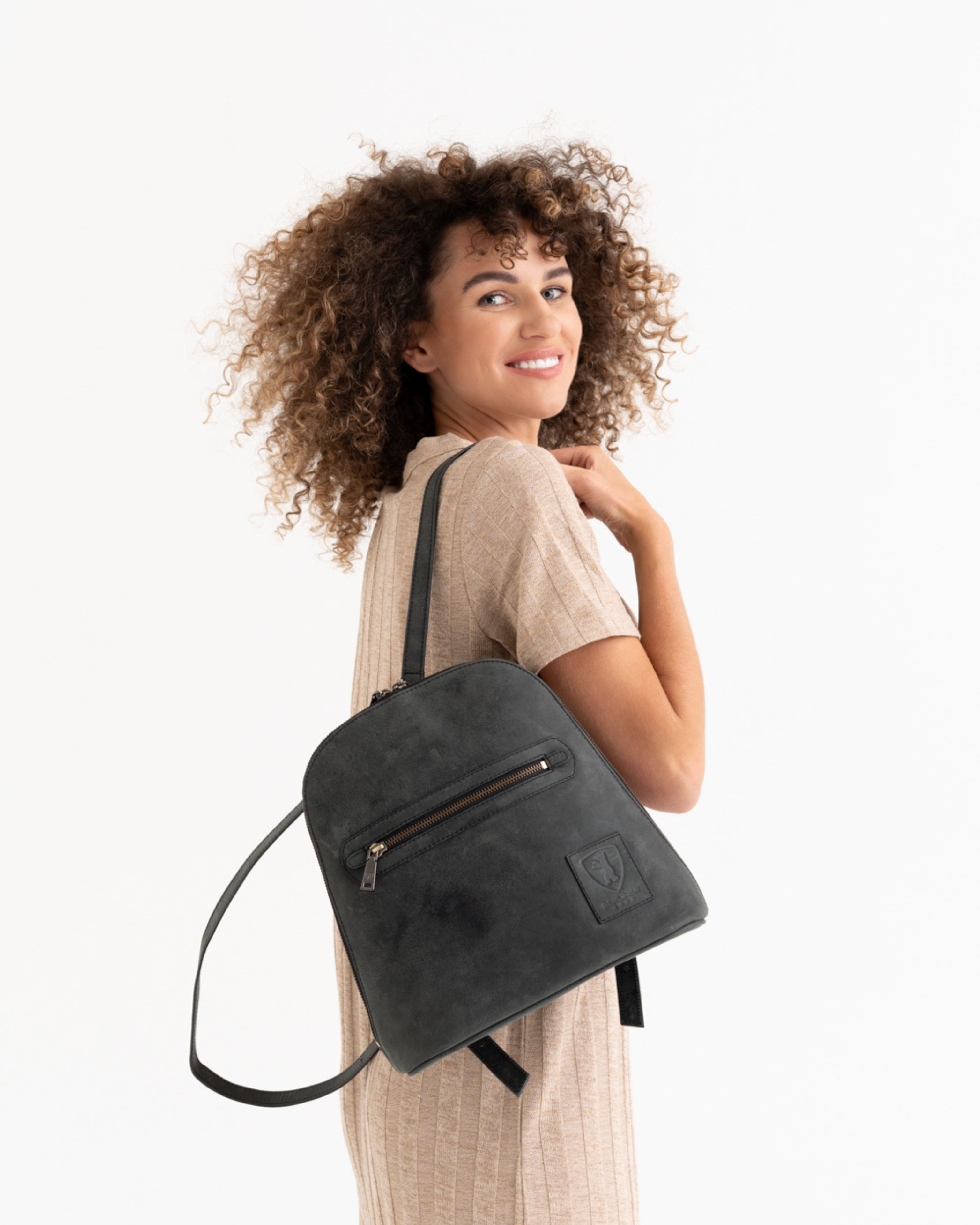 Woman wearing dark grey leather zip-around backpack