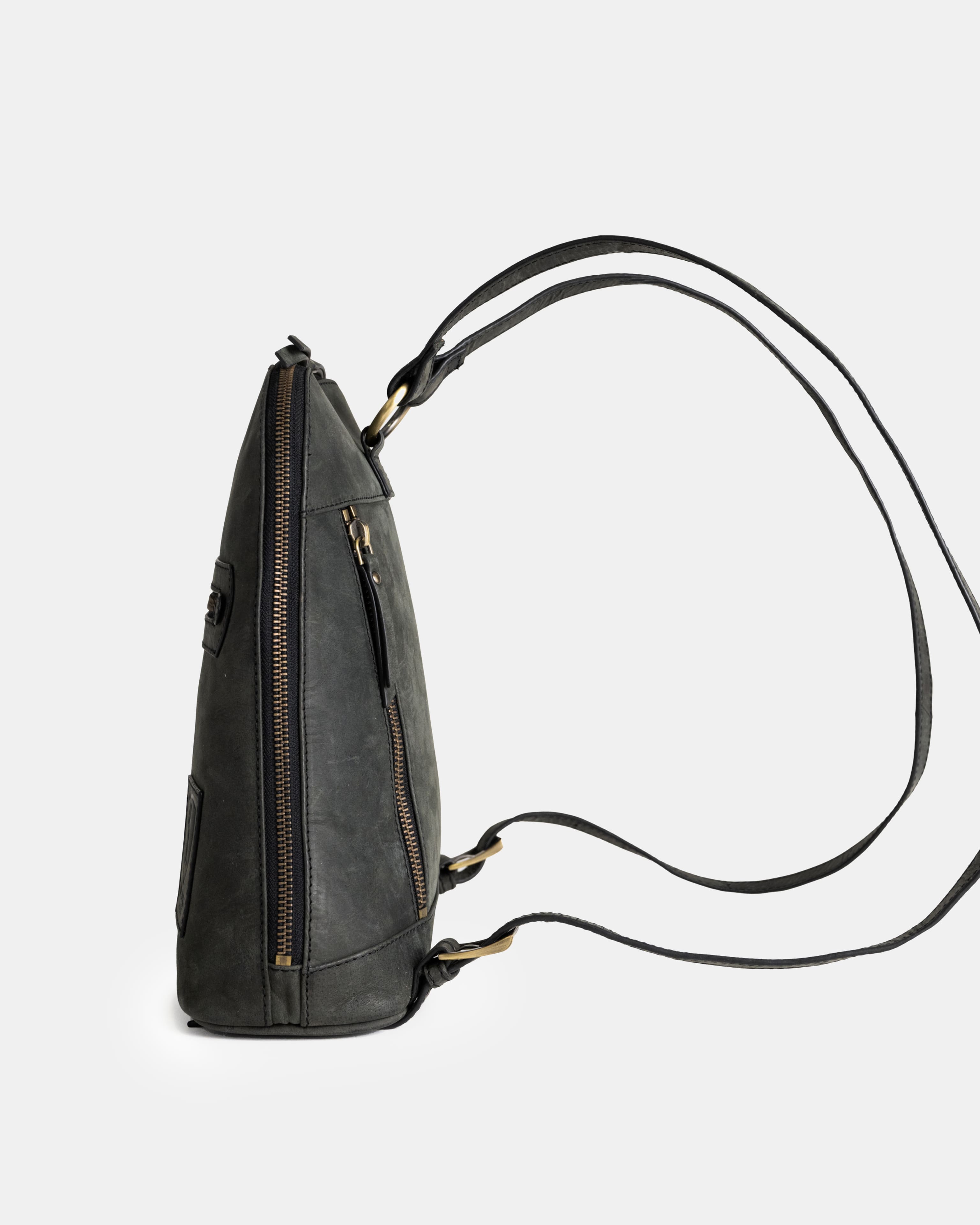 Side studio view of dark grey leather zip-around backpack