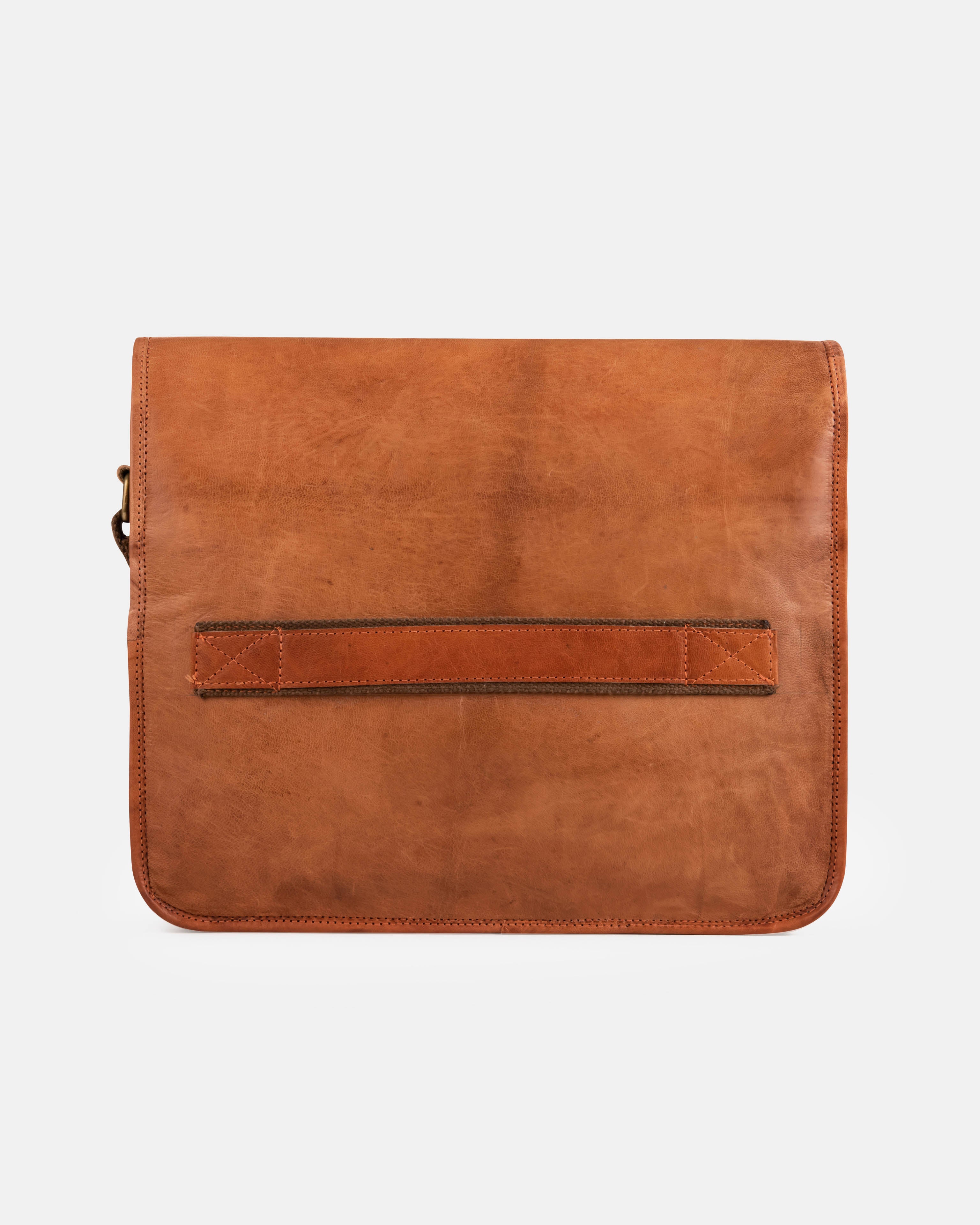 Rear view of a minimalist vintage leather messenger bag featuring a horizontal luggage trolley strap across the middle