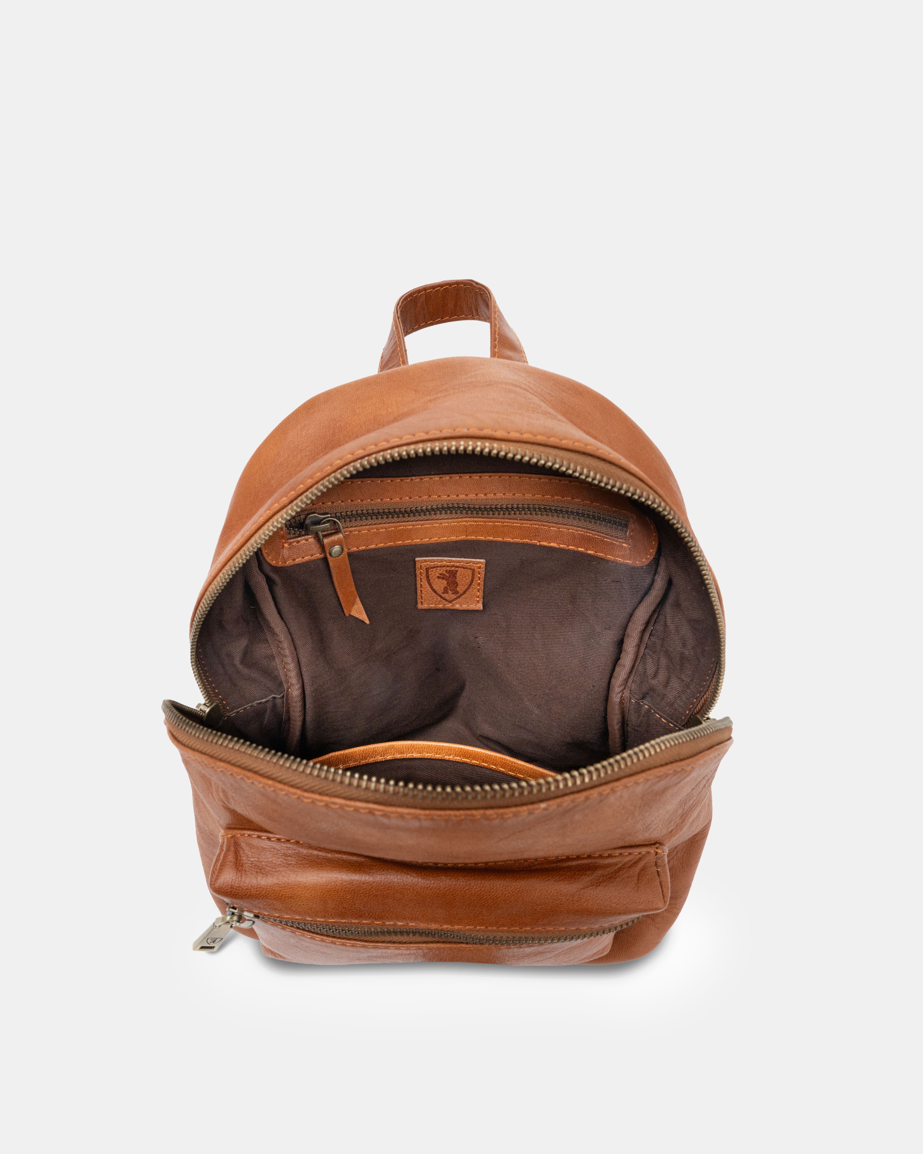 Top-down view of open vintage leather zip-around backpack showing interior compartment.