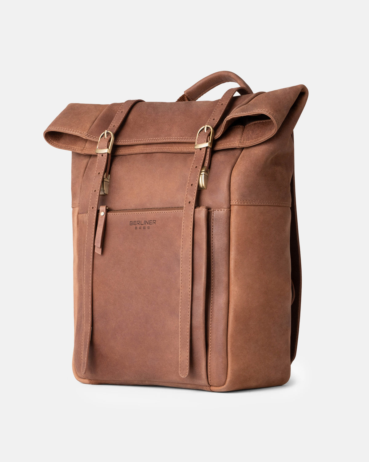 Three-quarter product view of a camel leather roll-top backpack with dual vertical buckle straps