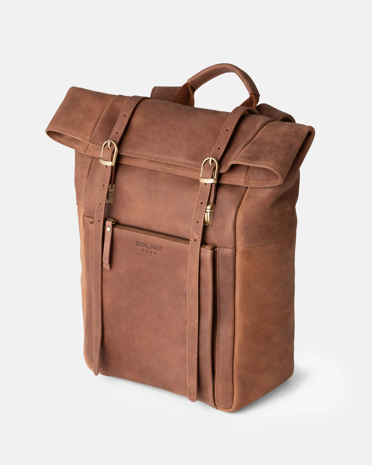 Three-quarter product view of a camel leather roll-top backpack with dual vertical buckle straps.