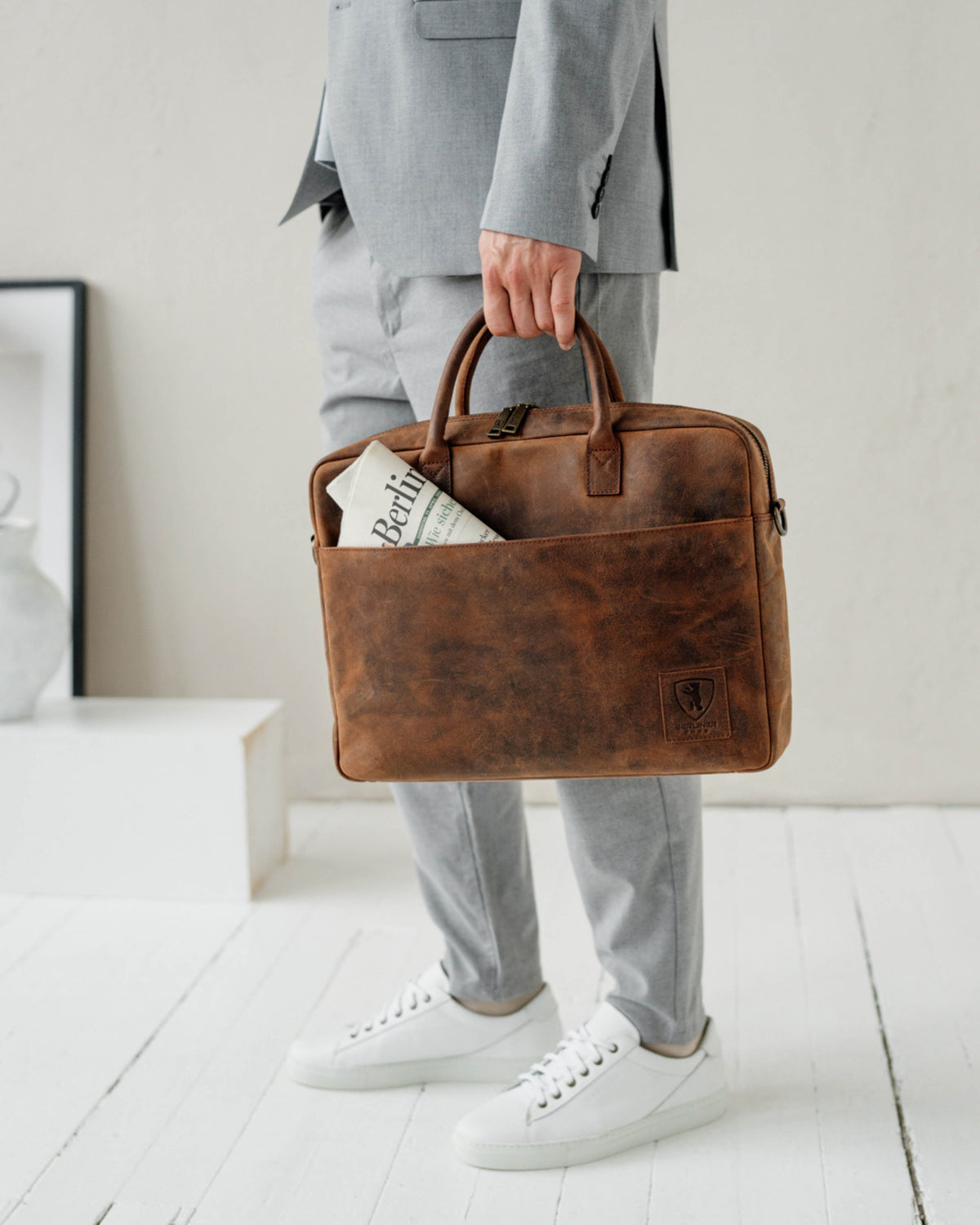 Front view of earth leather briefcase held by man