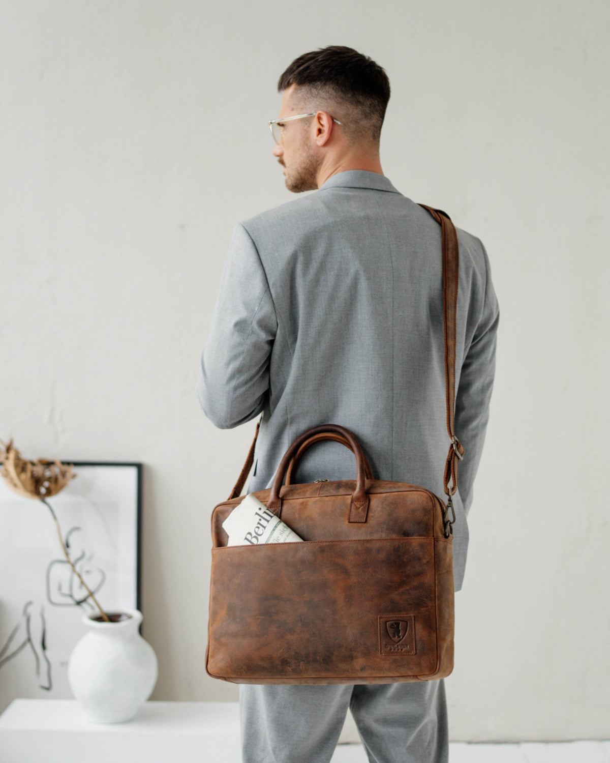 Front view of earth leather briefcase worn on shoulder