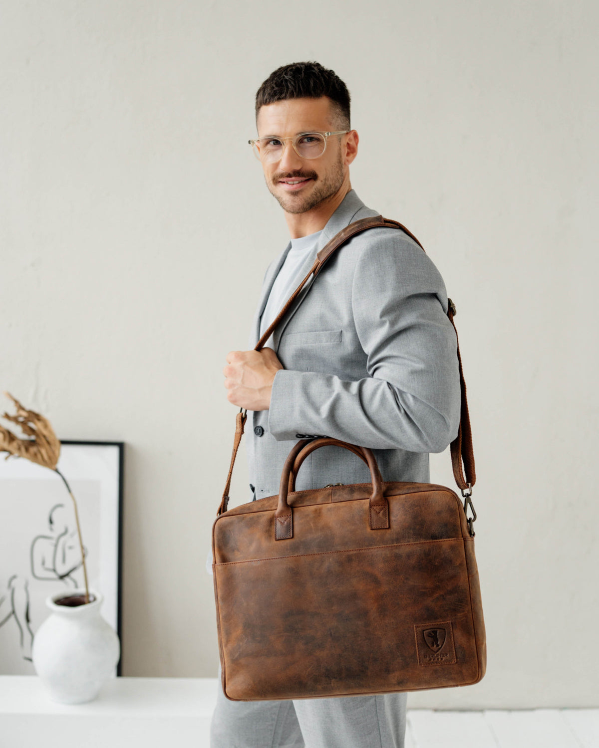 Man in grey suit carrying earth leather briefcase