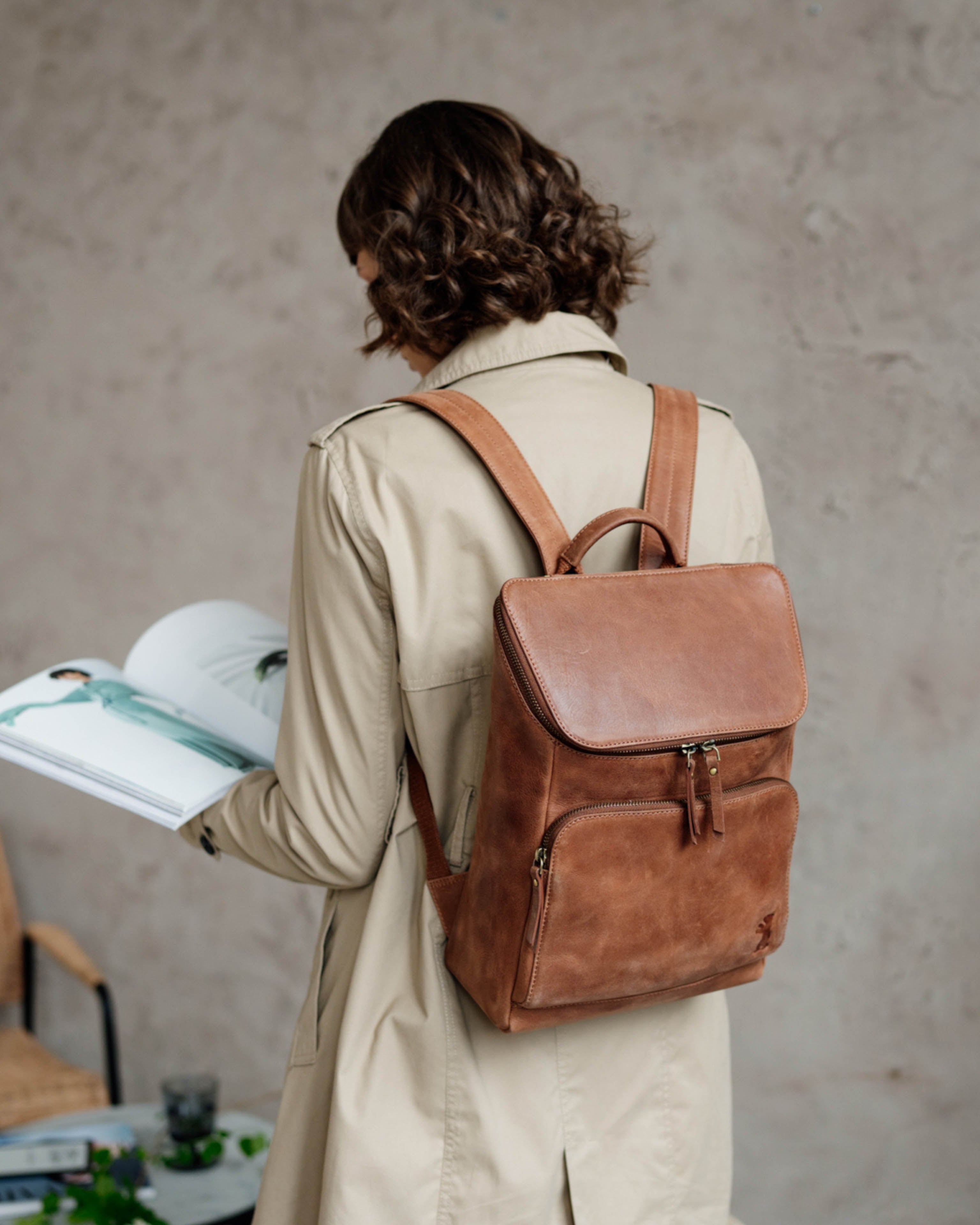 Rear view of person wearing camel leather zip-around backpack
