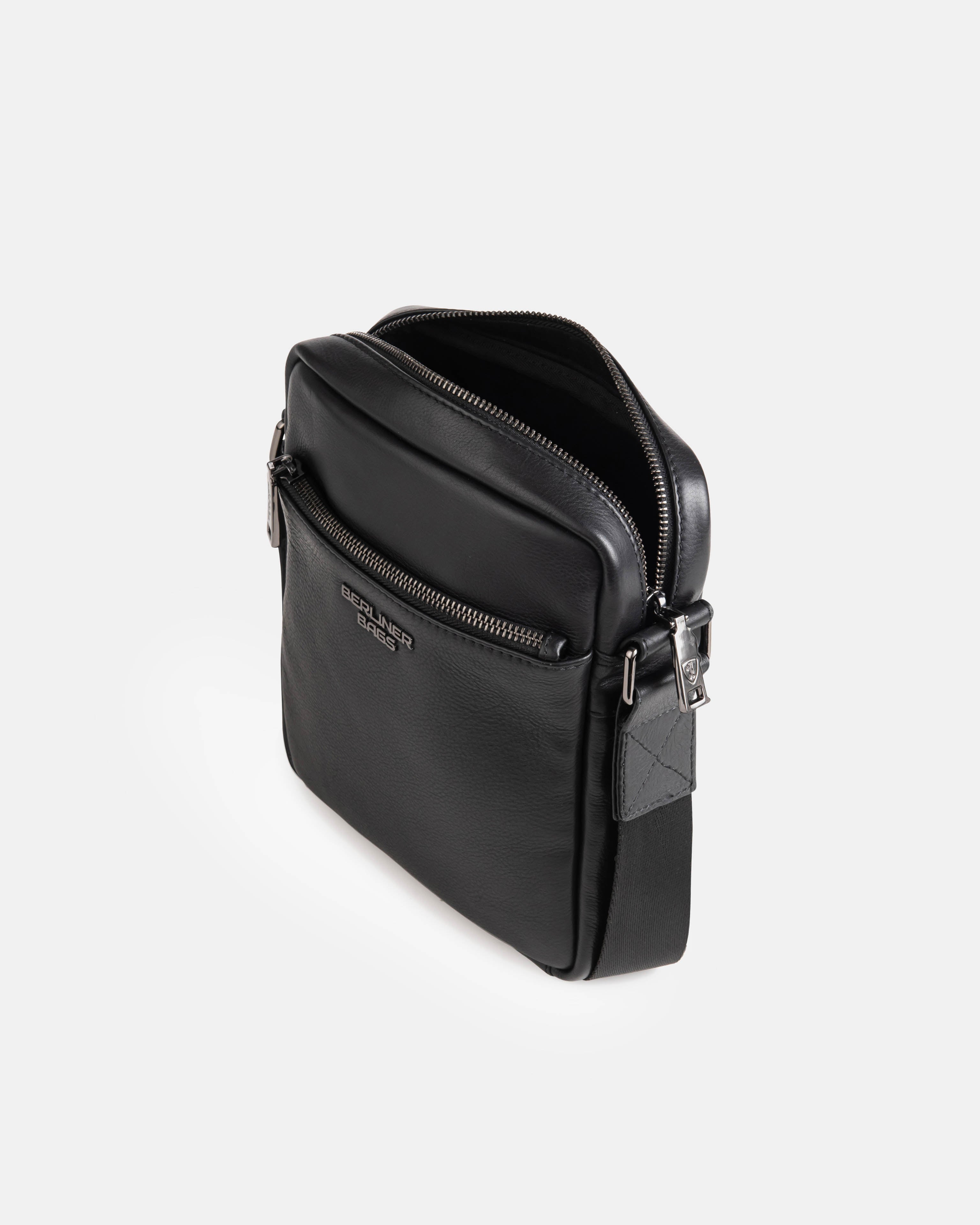 Angled top-down view of black leather messenger bag details