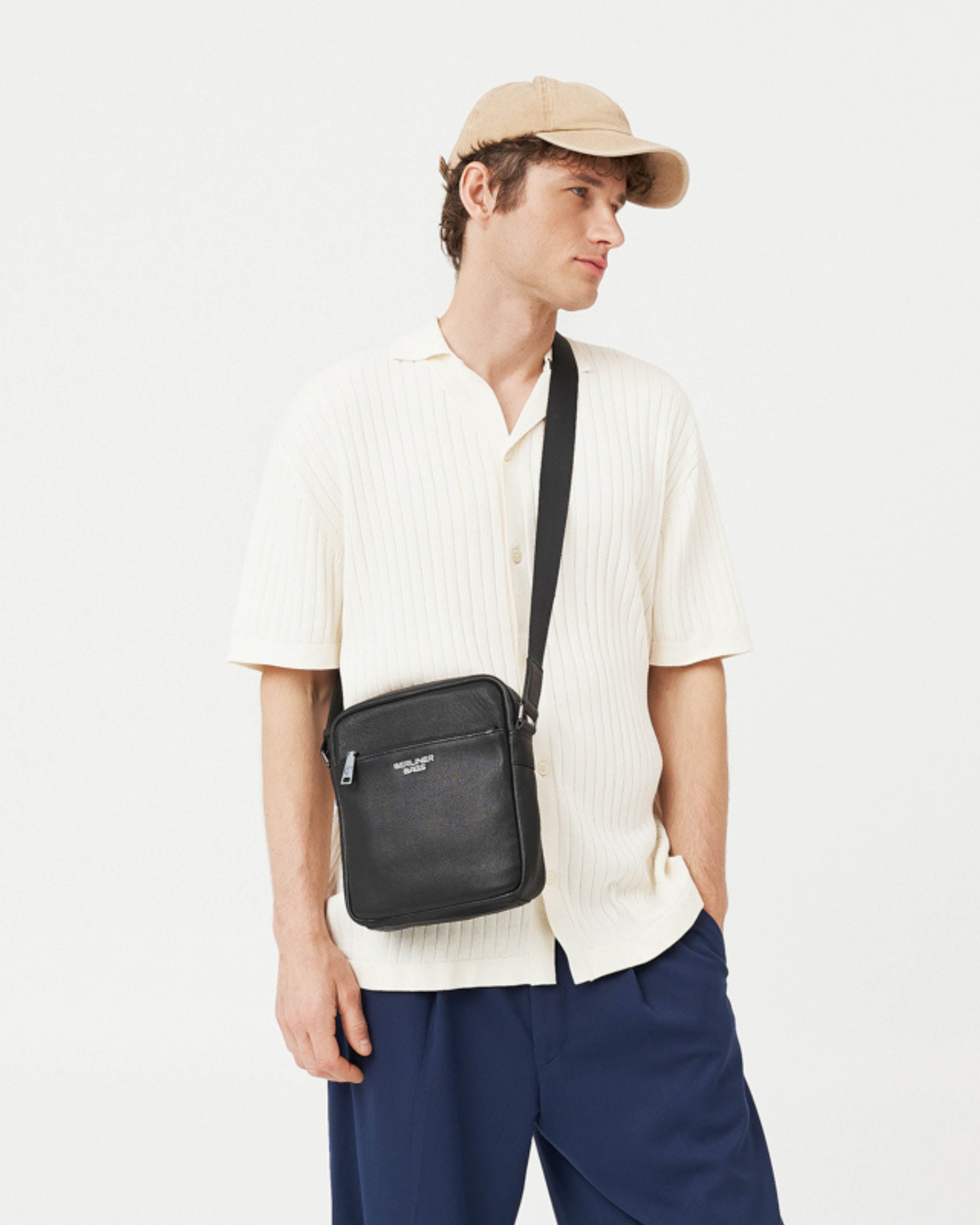 Man wearing black leather crossbody messenger bag with strap
