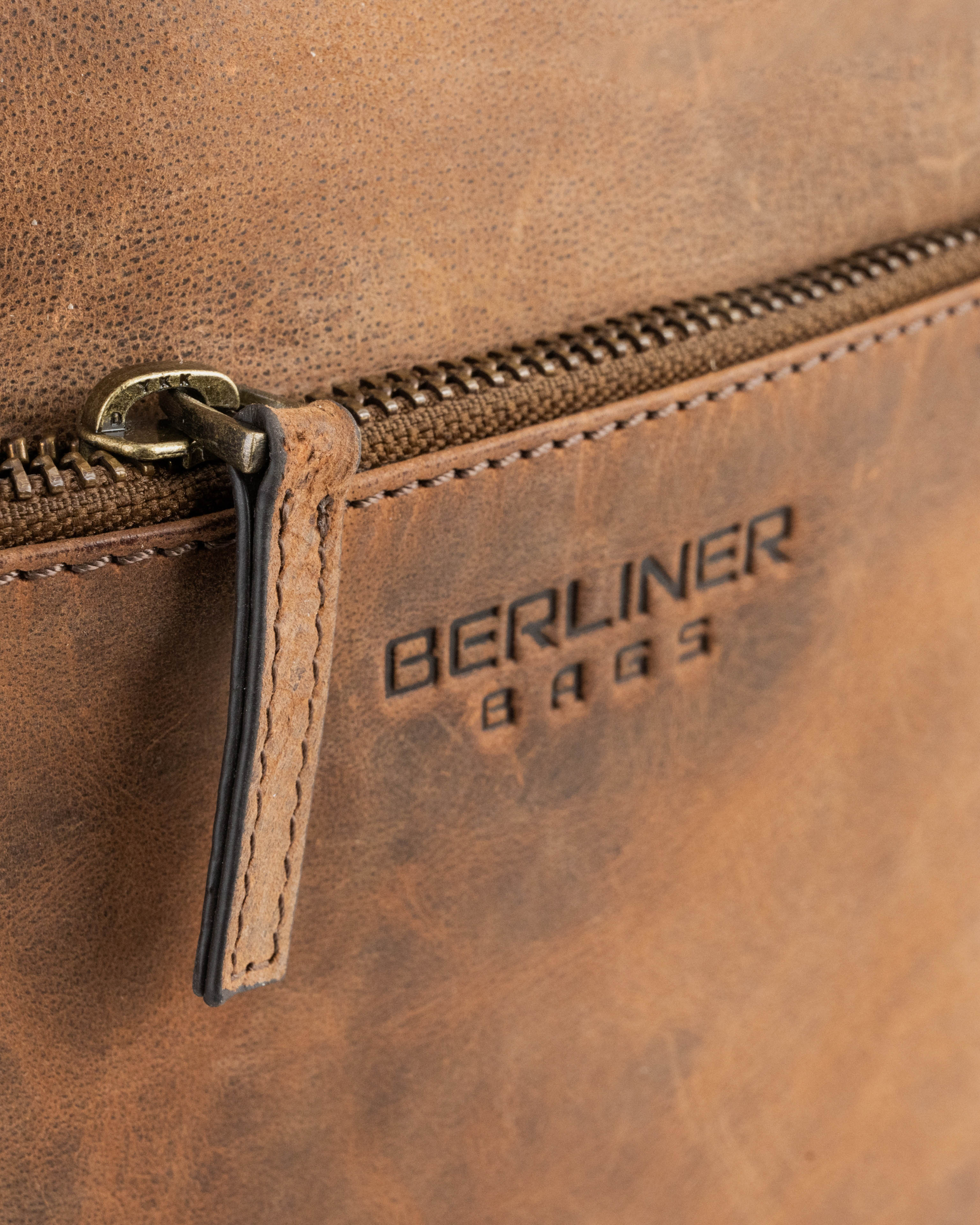 Close up of earth leather messenger bag zipper detail