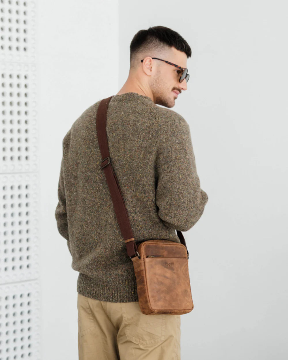 Back view of man wearing earth leather messenger bag