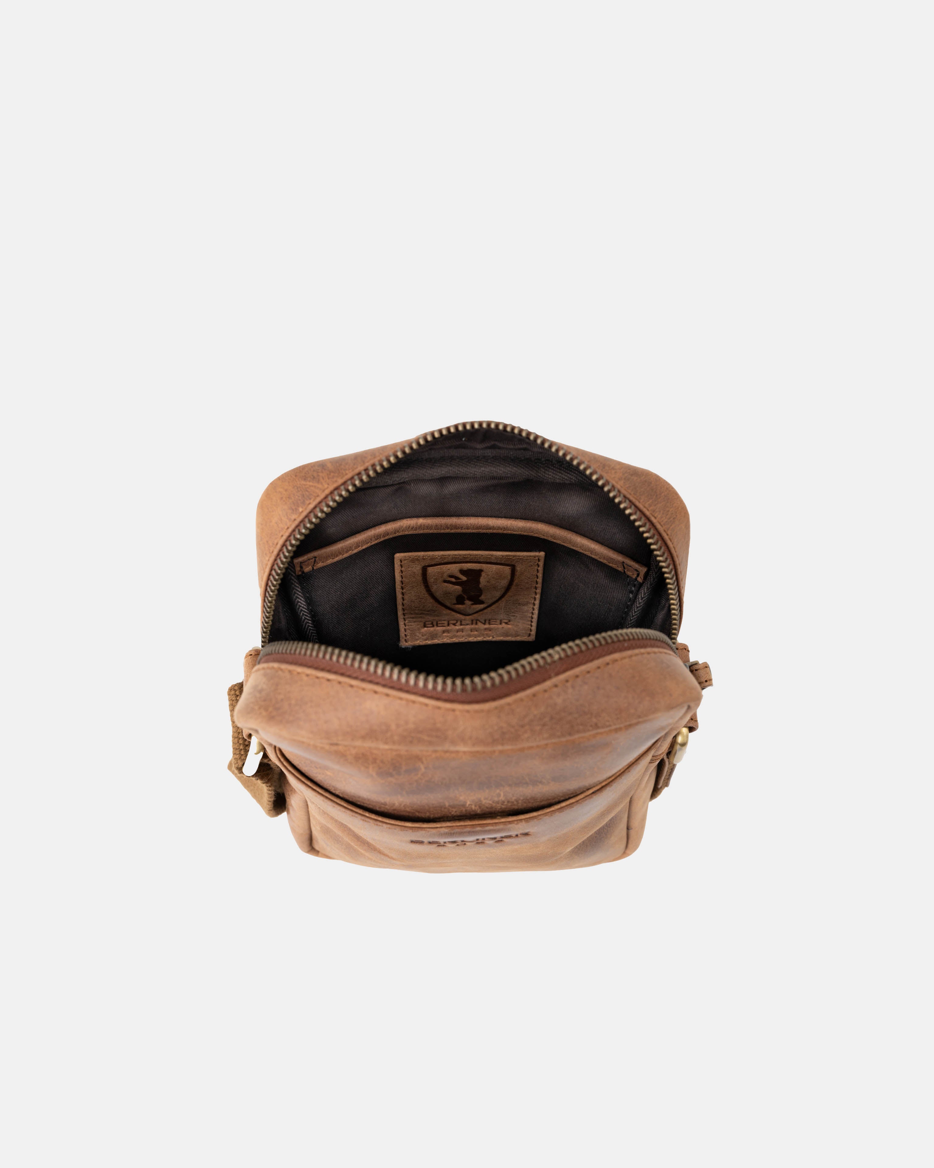 Top-down open view of camel leather messenger bag interior details