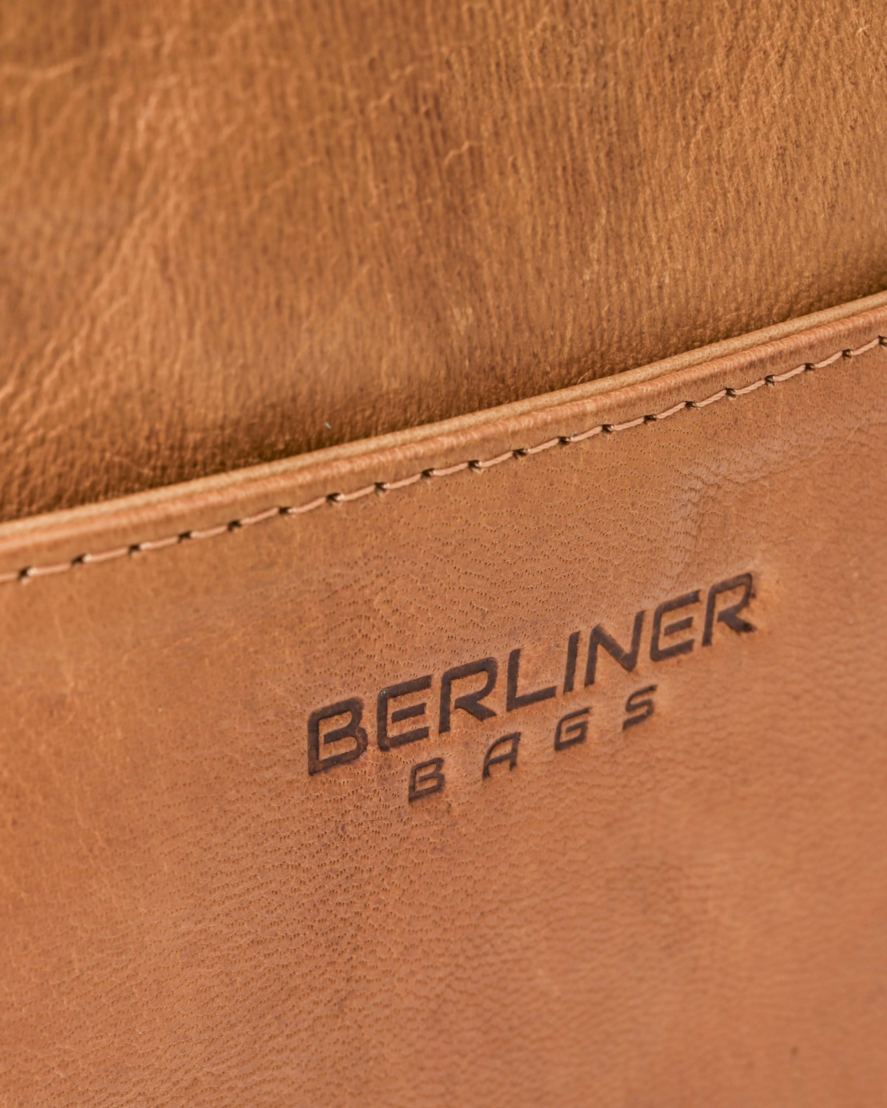 Close up view of the embossed brand logo on a vintage leather messenger bag
