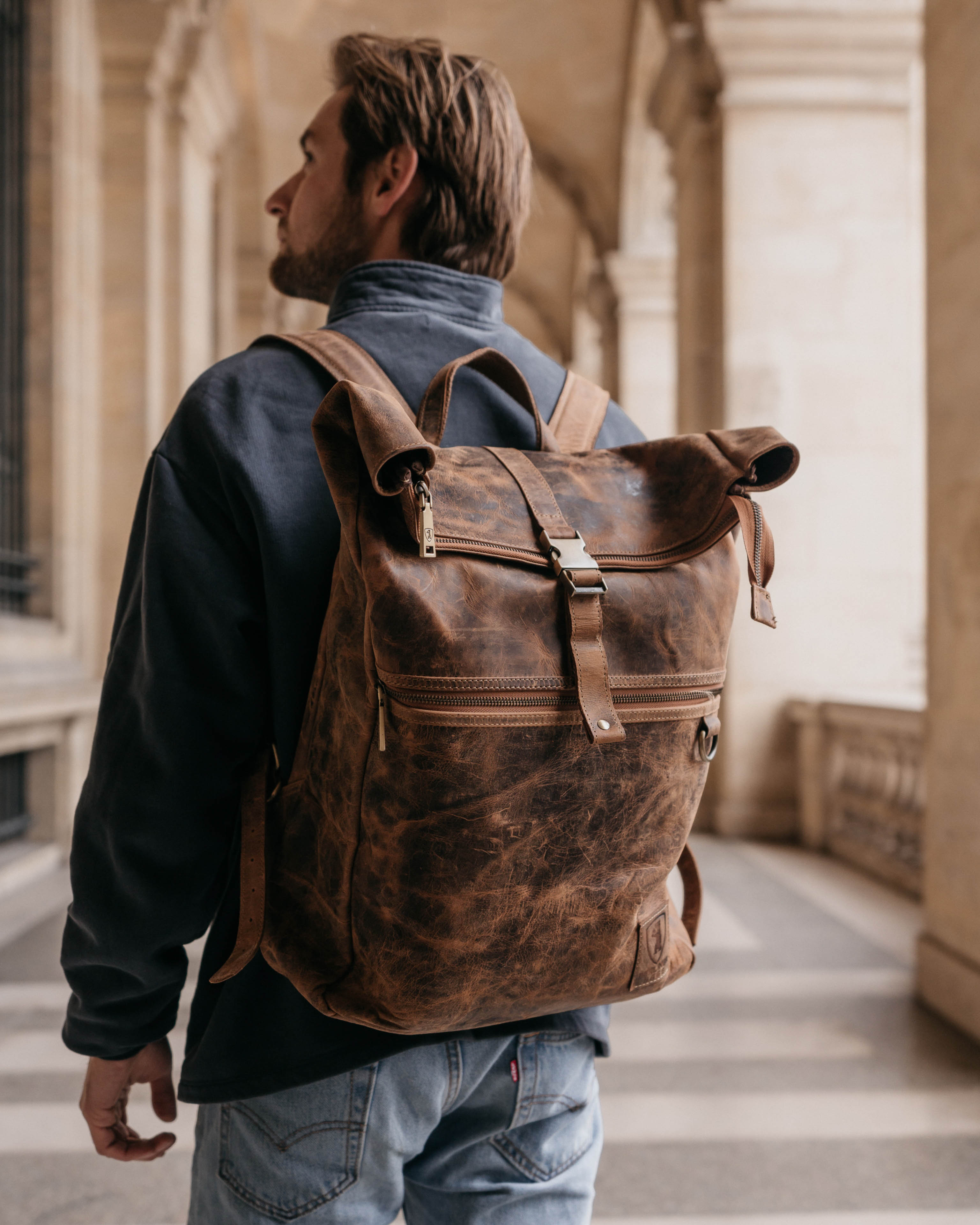 Side view of a walnut leather backpack bag with zipper