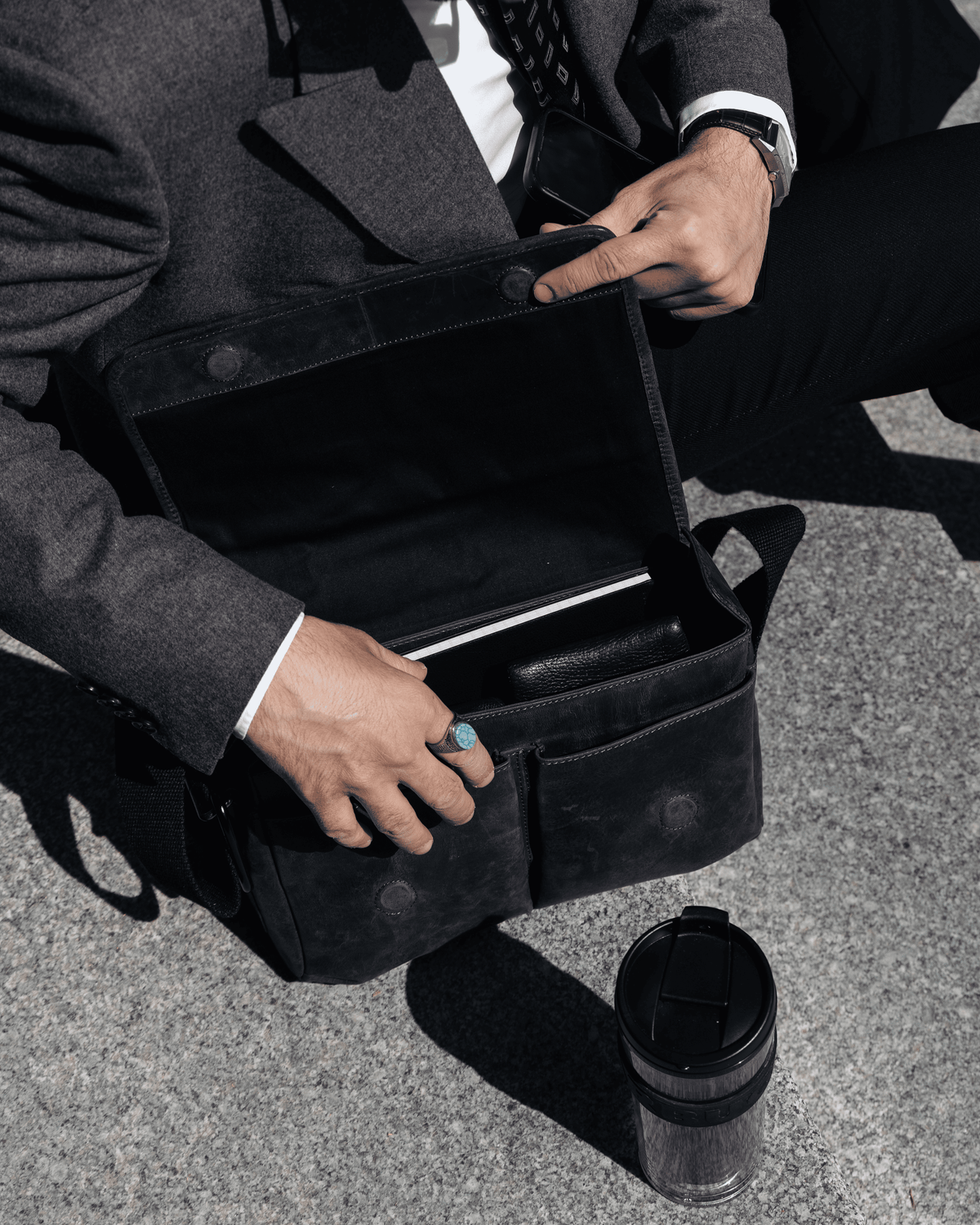 Inside view of a dark grey leather messenger bag with pockets