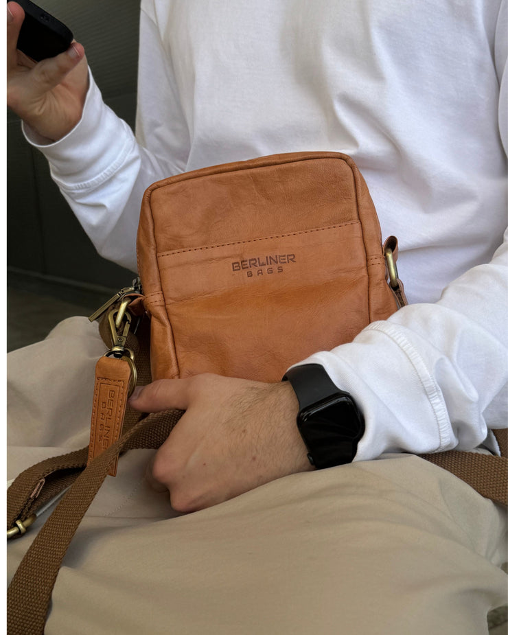 Close up of man wearing vintage leather messenger bag with strap