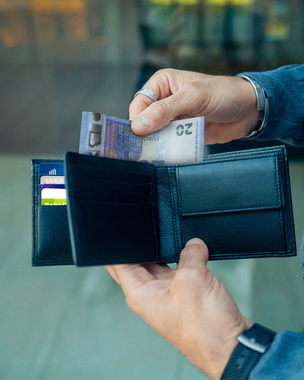 Man talking money out of carbon leather wallet