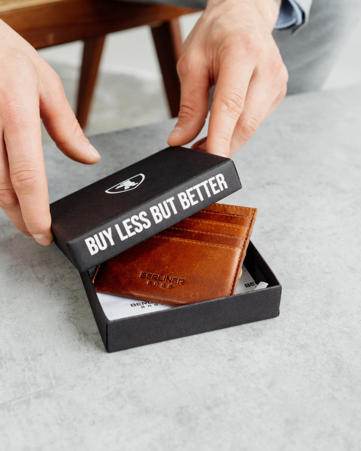 A cognac leather card case in the branded box