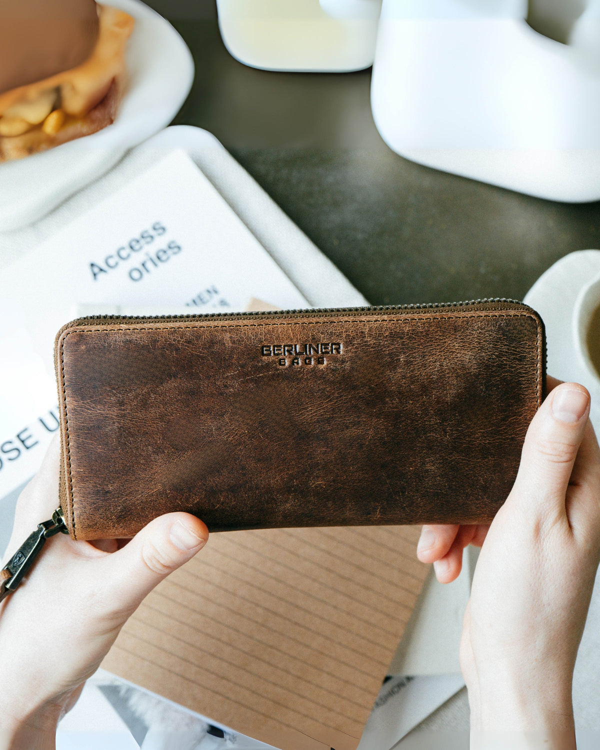 Person showing the front view of a walnut leather wallet
