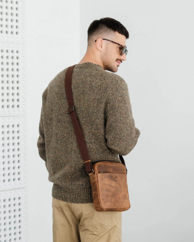 Back view of man wearing earth leather messenger bag
