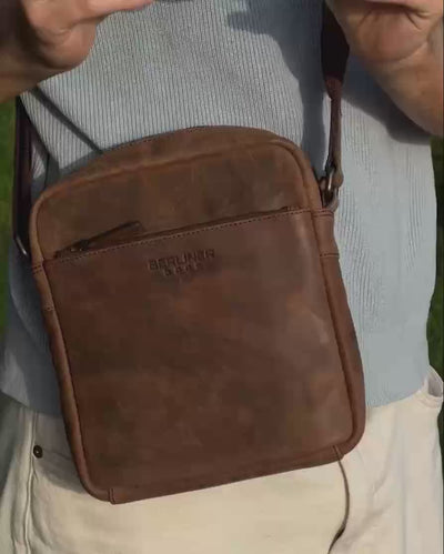 Close up of man wearing earth leather messenger bag