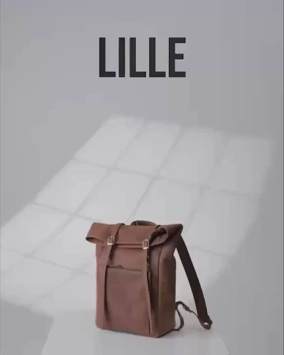 Three-quarter studio shot of a camel roll-top backpack with dual front straps